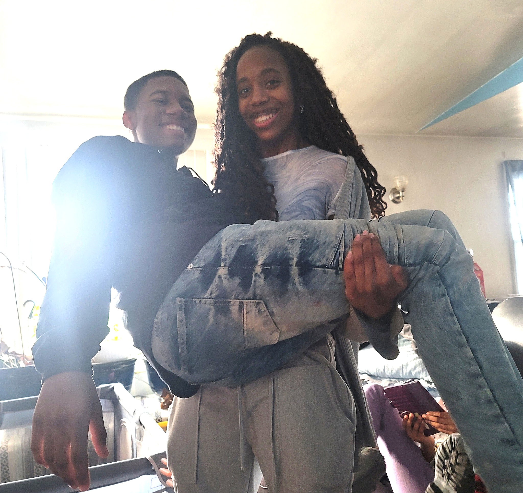 Azaria playfully holding Jelani as they smile together