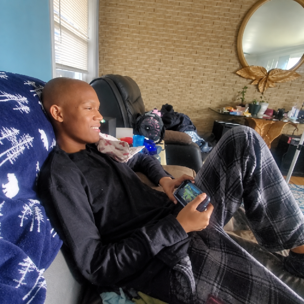 Jelani smiling while relaxing on the couch