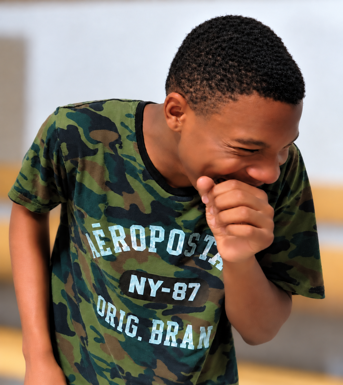 Jelani laughing warmly in his camouflage shirt