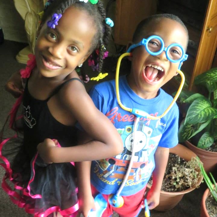 Young Jelani and Azaria playing with colorful glasses