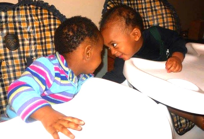 Jelani and Azaria touching foreheads as toddlers