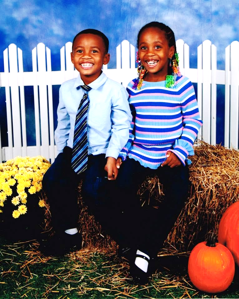 Young Jelani and Azaria sitting together outdoors